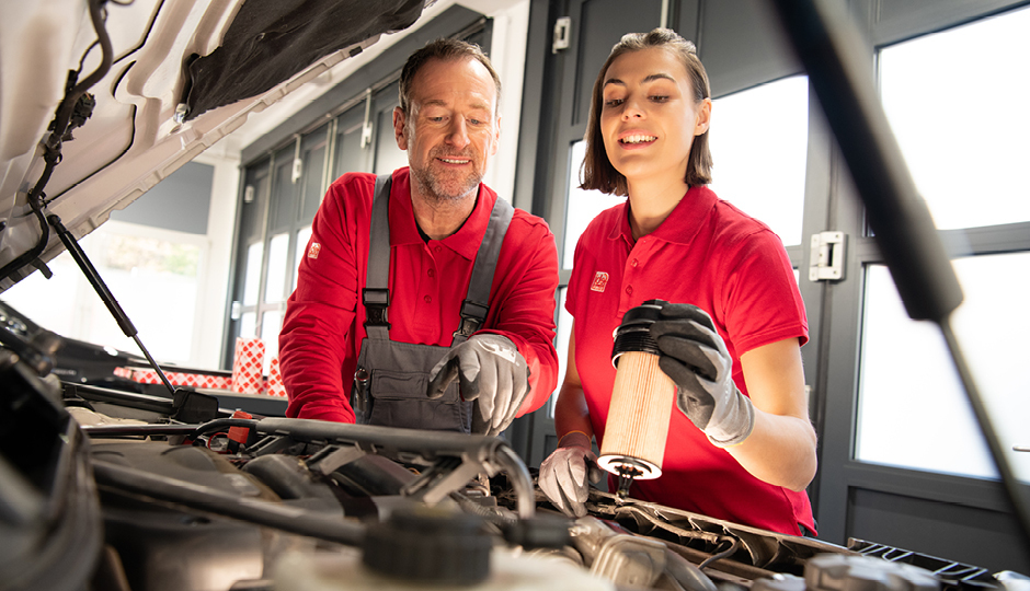 Male and female mechanic holding a filter ready to install in a workshop
