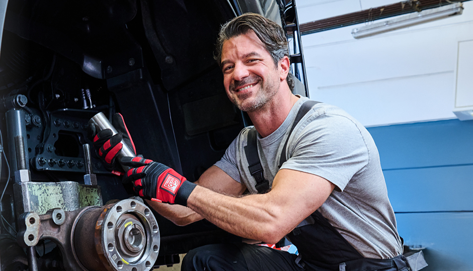 Mécanicien tenant un pivot prêt à être monté sur un camion